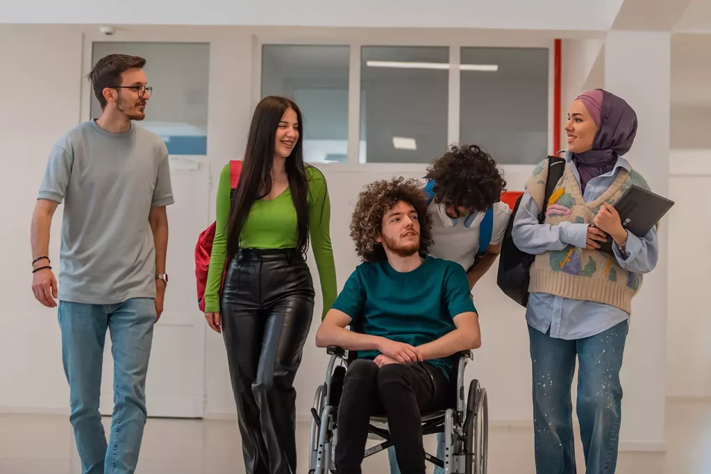 Diverse group of friends, one with disability in wheelchair, laughing and talking together