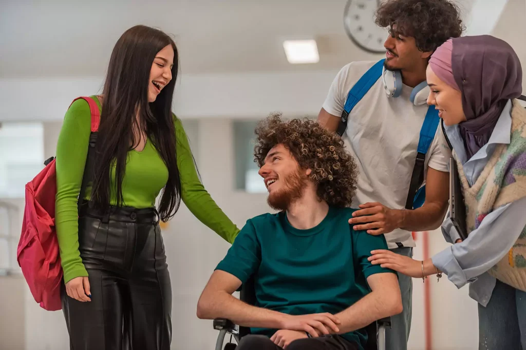 Diverse group of friends, one man disabled in wheelchair, all talking happily